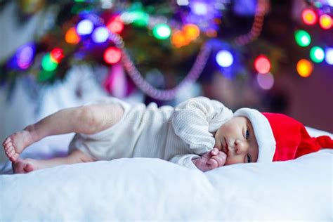 One Week Old Newborn Baby In Santa Hat Near Christmas Tree Stock Image