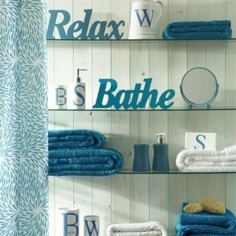 Bathroom decor brown and blue #tealandbrownbathroomdecor. Cool teal bathroom, glass shelves and white 3-d words ...
