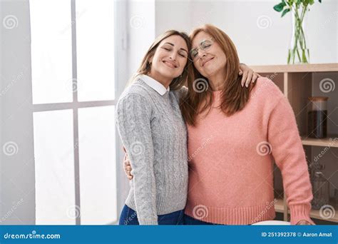 Mother And Daughter Hugging Each Other Standing At Home Stock Photo