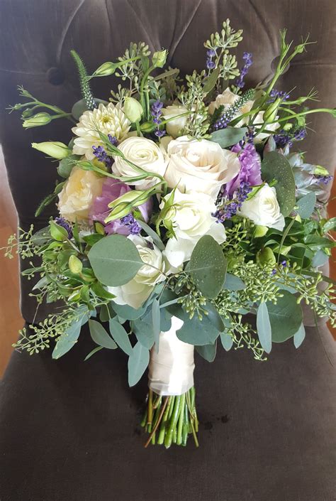 When it comes to floral trends, not a lot changes over time: Bridal bouquet, leafy green seeded eucalyptus, cream roses ...