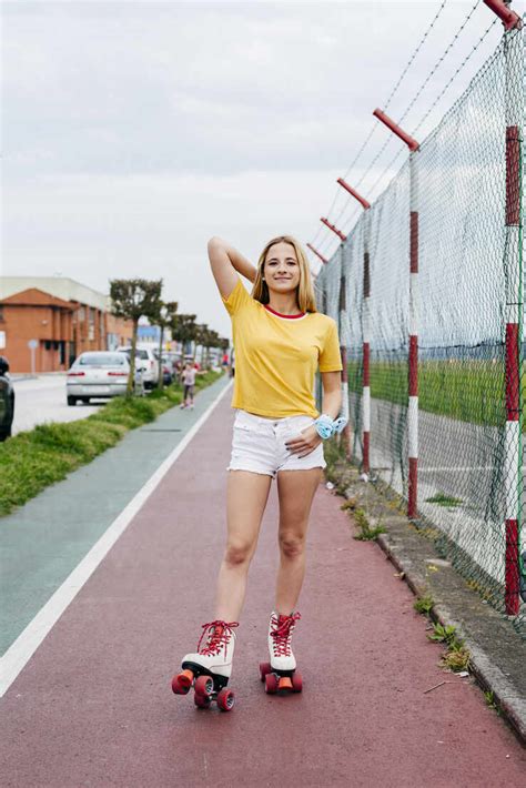 Casual Teen Girl In Shorts And Roller Skates Standing On Lane Of Sports