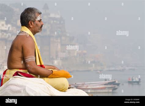 Brahmin Man Meditating At The Holy River Ganges In The Morning