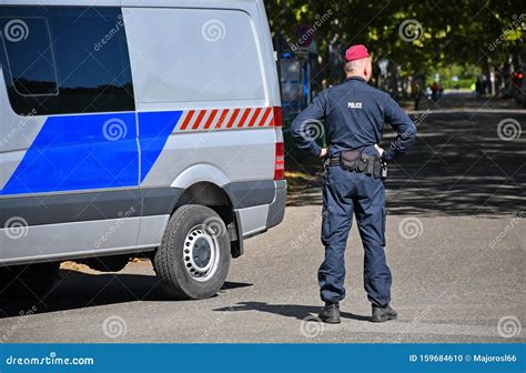 Police Officer Standing Next To A Patrol Car On The Street Editorial
