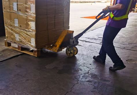 Worker Unloading Shipment Carton Boxes And Goods On Wooden Pallet By Forklift From Container