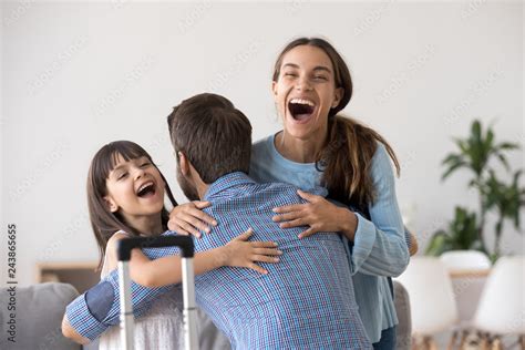 Excited Wife And Kid Daughter Hugging Father Arriving Returning After