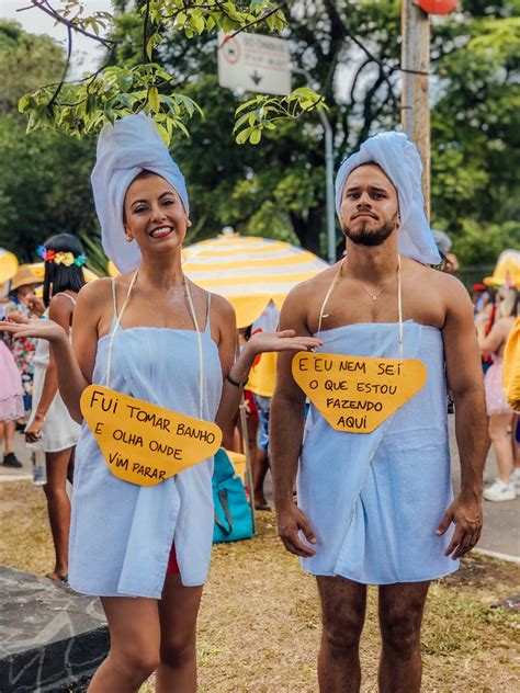 Two People Dressed In Costumes Standing Next To Each Other With Signs On Their Backs That Say