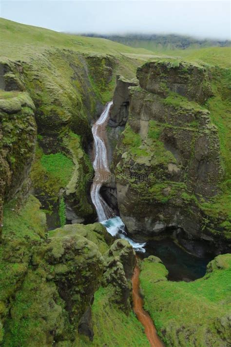 Waterfall At Fjadrargljufur Canyon River Cutting Through Green Rocks