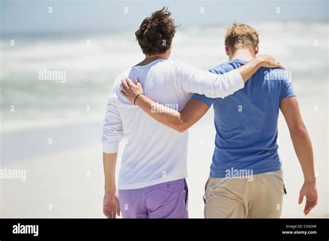 Rear View Of Two Men Walking With Their Arms Around Each Other Stock Photo Alamy