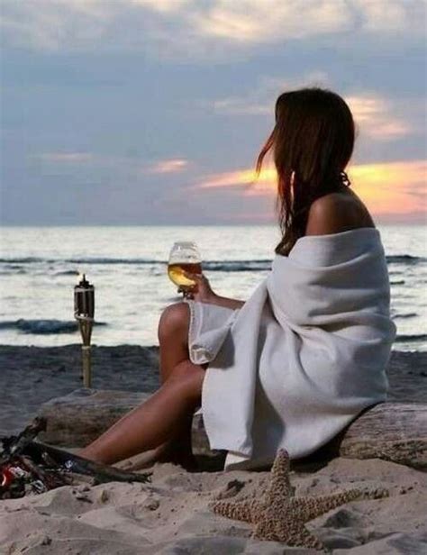 A Glass And Wine And The Ocean Woman Sitting On A Beach And Holding A