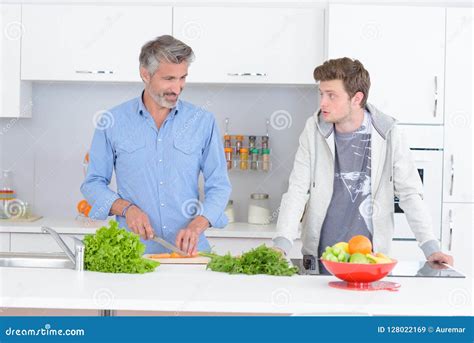 Padre E Hijo En La Cocina Que Prepara Verduras Imagen De Archivo