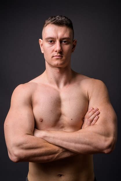 retrato de jovem homem bonito fitness musculoso sem camisa e com os braços cruzados foto premium