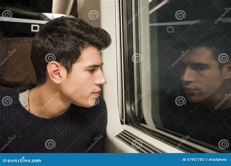Young Man Travelling In Train Looking Out Of Window Stock Image Image