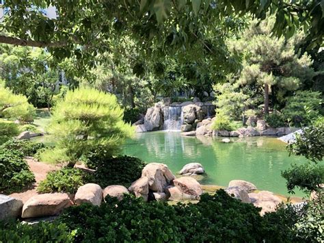 The Waterfall Is Perfectly Framed By Greenery Rocks And Water We