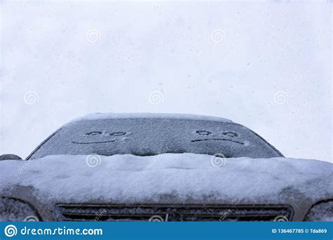 The Sad And The Happy Smile On The Snowy Windshield Of A Car Stock