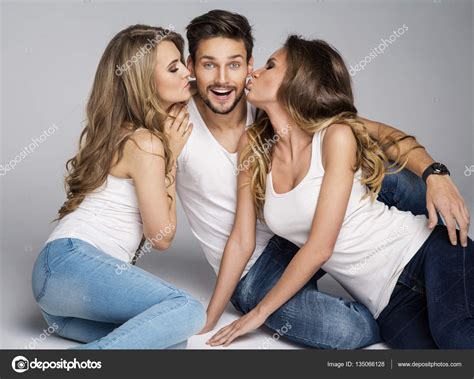 dos mujeres besándose guapo hombre — foto de stock 135066128 © kiuikson