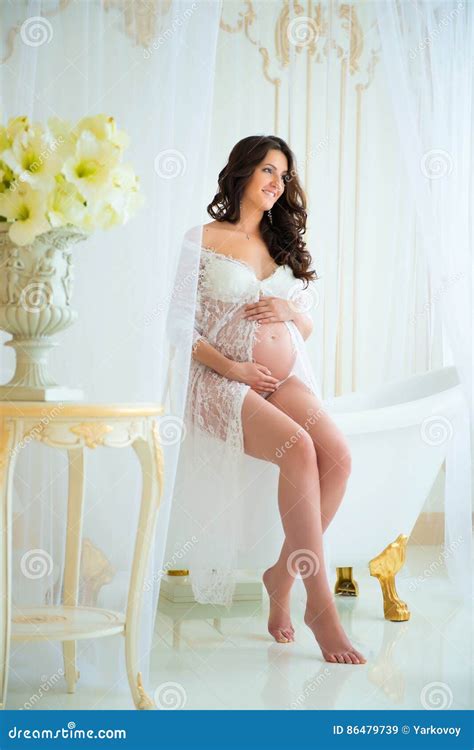 Beautiful Pregnant In Light White Lace Negligee In The Bathroom Stock