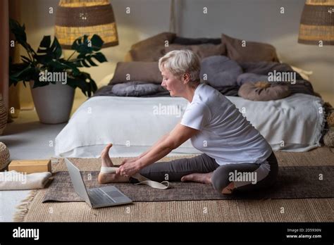Senior Woman Practicing Yoga Concept Sitting In Janu Sirsasana