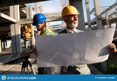 Architect And Construction Engineer Or Surveyor Discussion Plans And