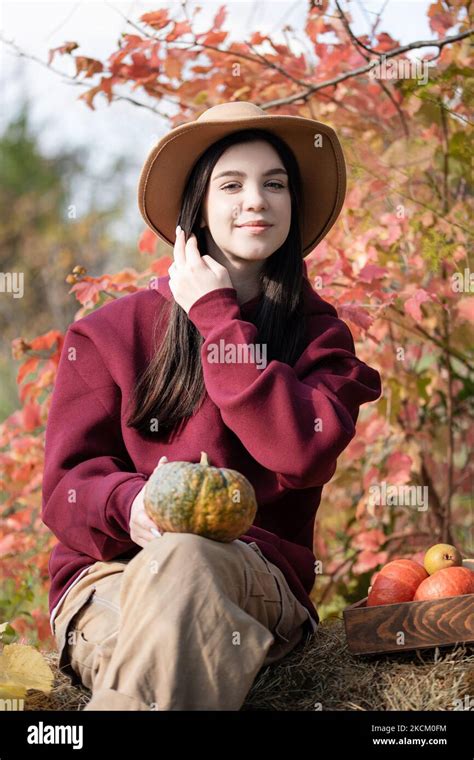 caucasian teen girl sitting in autumn park she is holding orange pumpkin in her hands fall