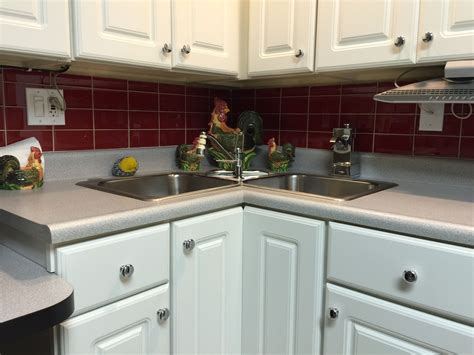 Beautiful kitchen features white cabinets paired with white marble countertops and a gray subway tiled backsplash. Nice pop of color using Red Glass Subway Tile backsplash ...