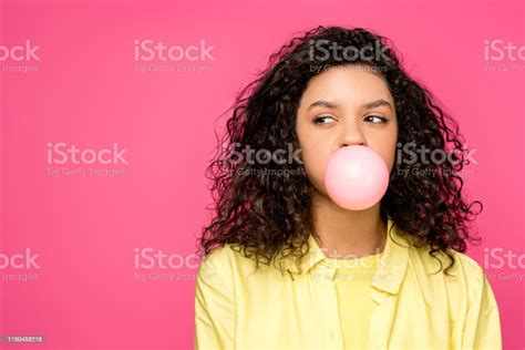 Curly African American Girl Blowing Bubble Gum Isolated On Crimson
