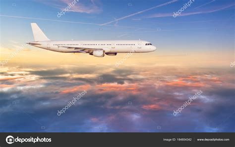 Airplane Jetliner Flying Above Clouds In Beautiful Sunset Light