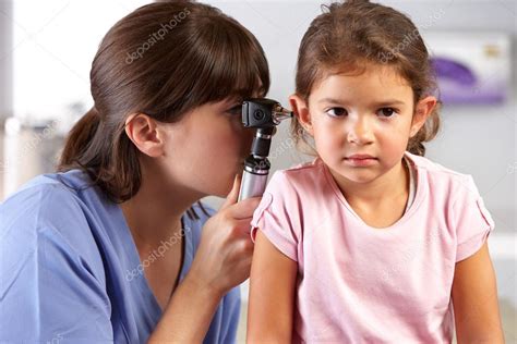 Doctor Examining Childs Ears In Doctors Office Stock Photo By