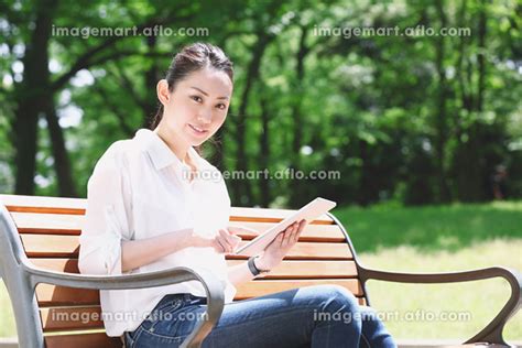 公園のベンチに座る日本人女性の写真素材 129118267 イメージマート
