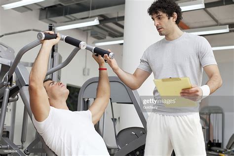 Personal Trainer Assisting A Client In The Gym High Res Stock Photo