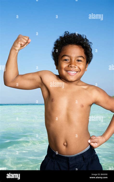 Boy Flexing His Muscles On The Beach Stock Photo Alamy