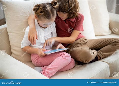Brother Teaching His Sister How To Use The Tablet Stock Image Image