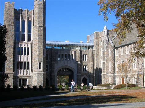 Cheerful man holding digital tablet with blank screen while standing near university campus. 7 of the US's Most Beautiful College Campuses