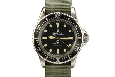 A watch face that has a black base colour which helps to define the white numbering. 1972 Rolex British Military Submariner Ref 5513 Watch For ...