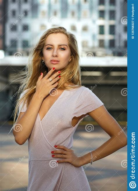 amazing blonde woman with long lush hair enjoying warm summer evening outdoor fashion concept