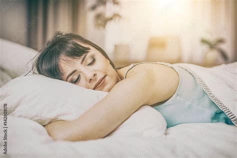 Beautiful Young Woman Sleeping On A Bed In The Bedroom Stock Photo