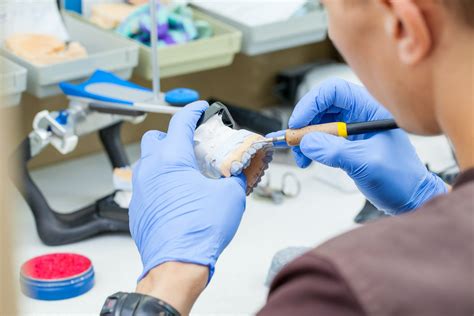 A dental technician dentist working with prostheses in a laboratory ...