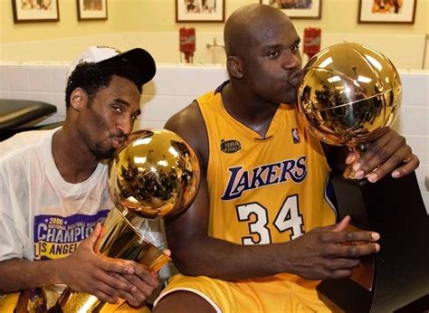 Kobe Bryant Kisses The Nba Championship Trophy As Shaquille Oneal