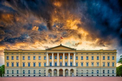 A Large Building With Many Windows On The Top Floor And Clouds In The