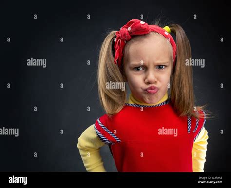 Funny Little Girl Making Faces Over Grey Background Stock Photo Alamy