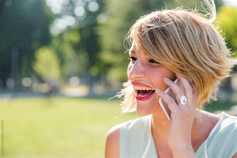 Woman Having Fun Conversation On Phone Outside By Stocksy Contributor Jovo Jovanovic Stocksy