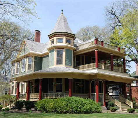 Green Red And Yellow Victorian Home With Large Round Front Porch And