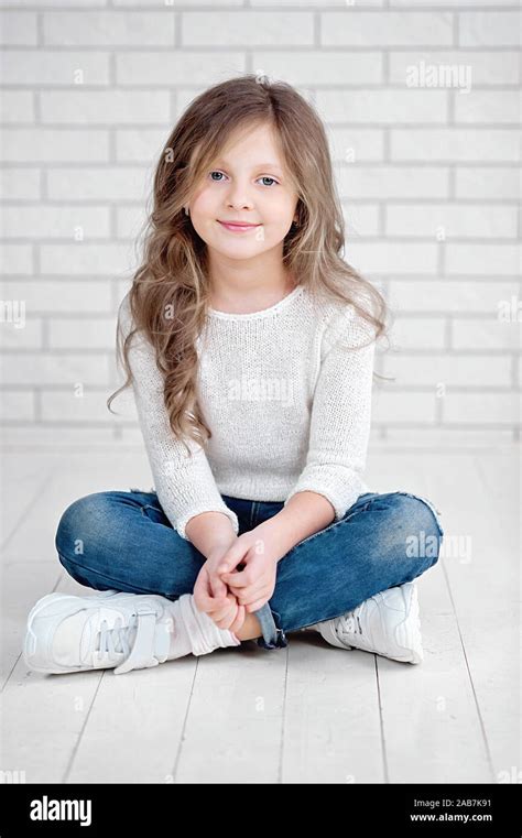Portrait Of Cute Little 7 Years Old Girl Smiling And Sitting On White