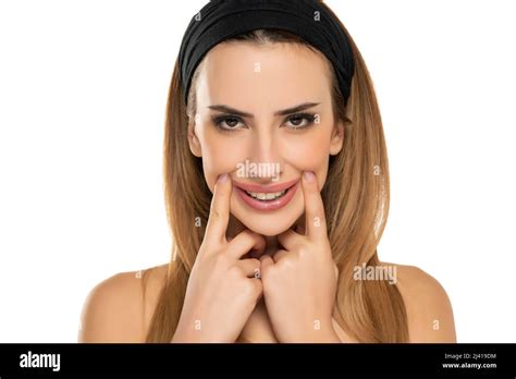 Portrait Of Young Woman Stretching Mouth In Fake Smile With Her Fingers