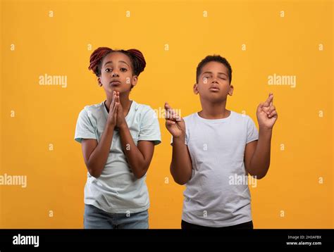 Innocent African American Kids Praying On Yellow Stock Photo Alamy
