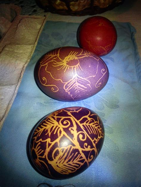 Three Painted Eggs Sitting On Top Of A Blue Cloth