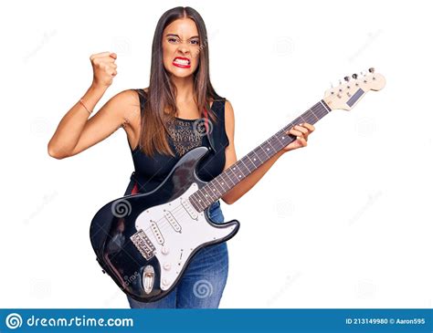 Young Hispanic Woman Playing Electric Guitar Annoyed And Frustrated