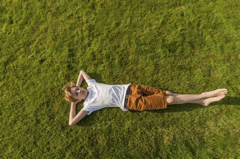 Teenage Boy Lying In Grass Stock Photo