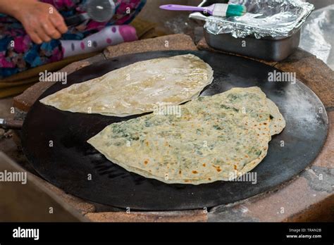 turkish woman prepares gozleme traditional dish in the form of flatbread stuffed with greens