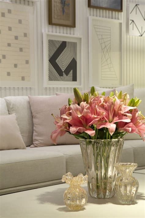 A Vase Filled With Pink Flowers Sitting On Top Of A Table Next To A Couch