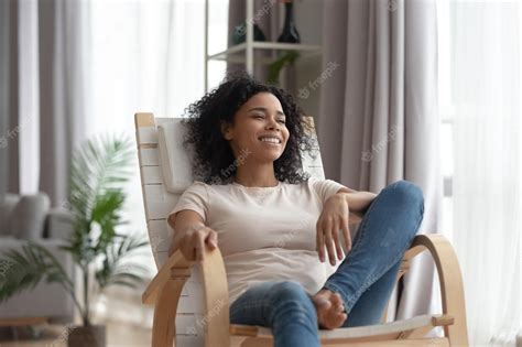 Premium Photo Smiling Calm Young Black Woman Relaxing On Comfortable Wooden Rocking Chair In